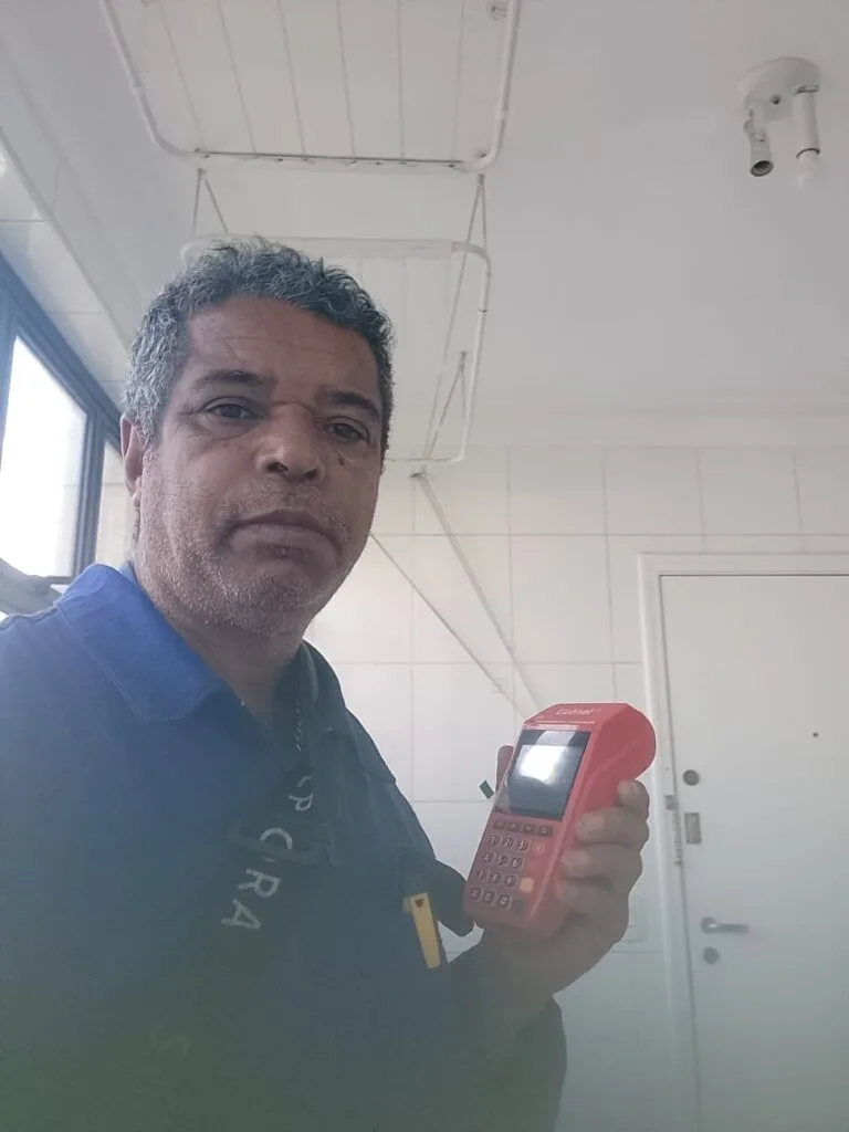 Seu Domingos Eletricista segurando a maquininha vermelhinha da Getnet, pronto para concluir mais um atendimento com confiança e profissionalismo.